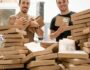 a couple of men standing next to a pile of boxes